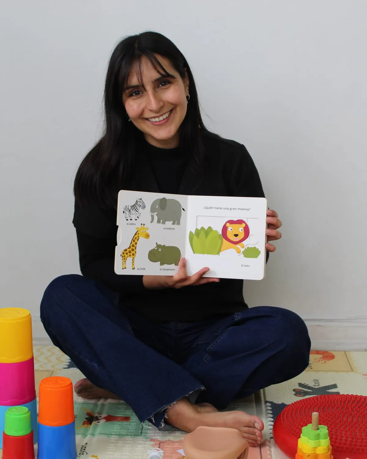 Vania Sanhueza, fonoaudióloga y fundadora, con un libro ilustrado en la sala de FonoSer