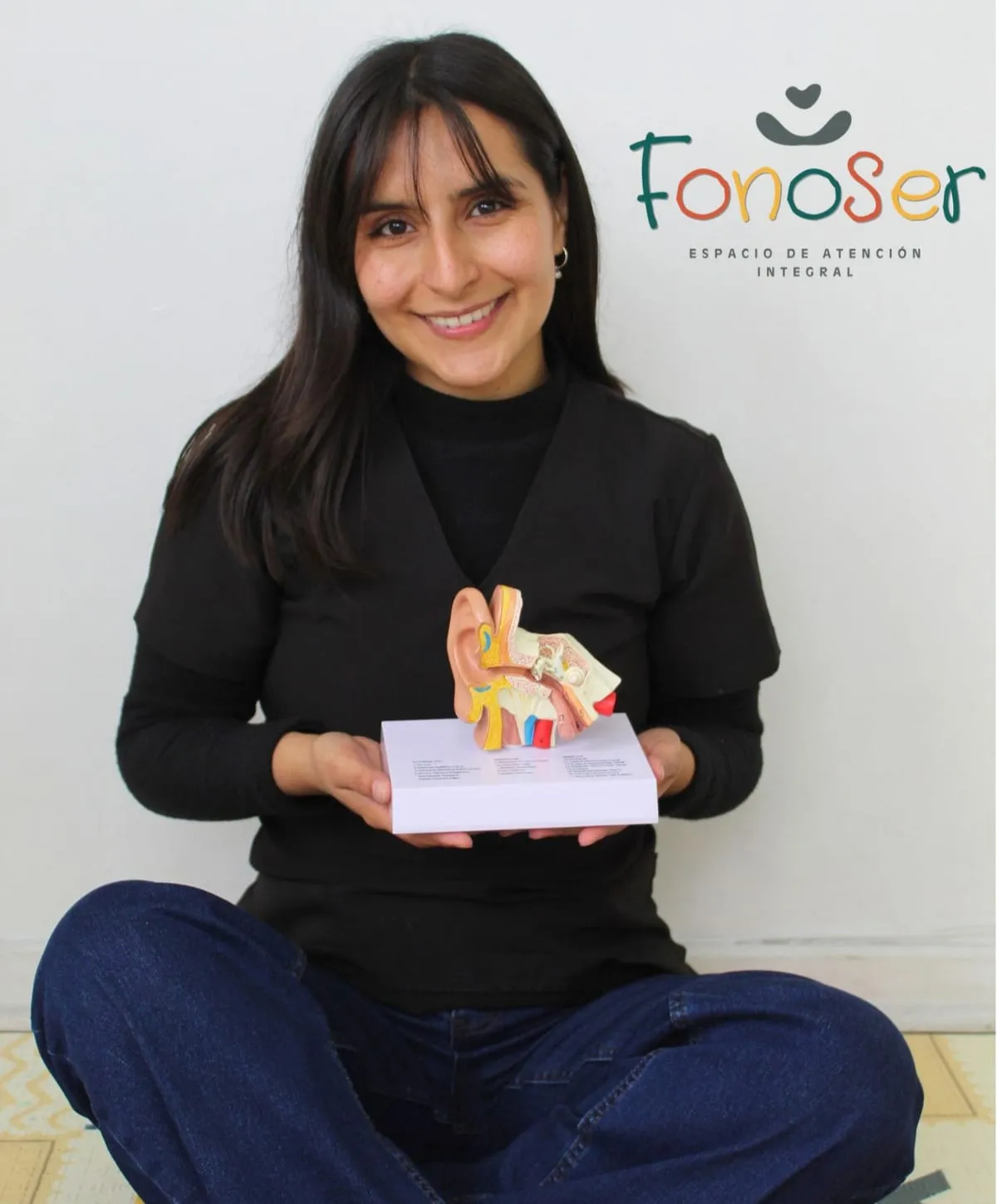 Vania Sanhueza, fonoaudióloga y fundadora, con un modelo anatómico del oído en la consulta de FonoSer
